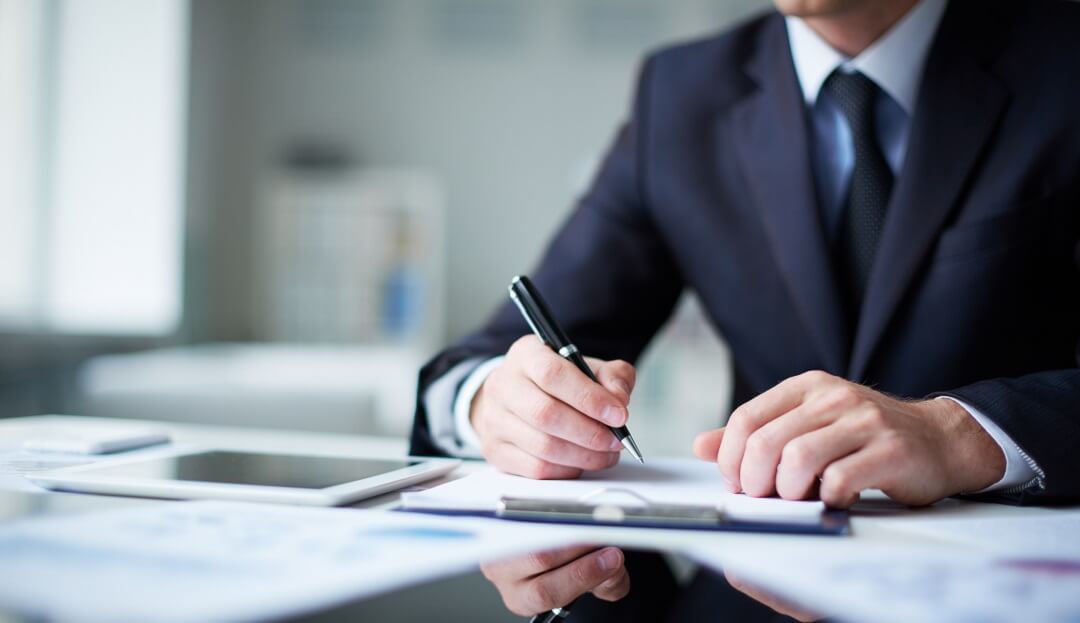 Close up of male hands with pen over document