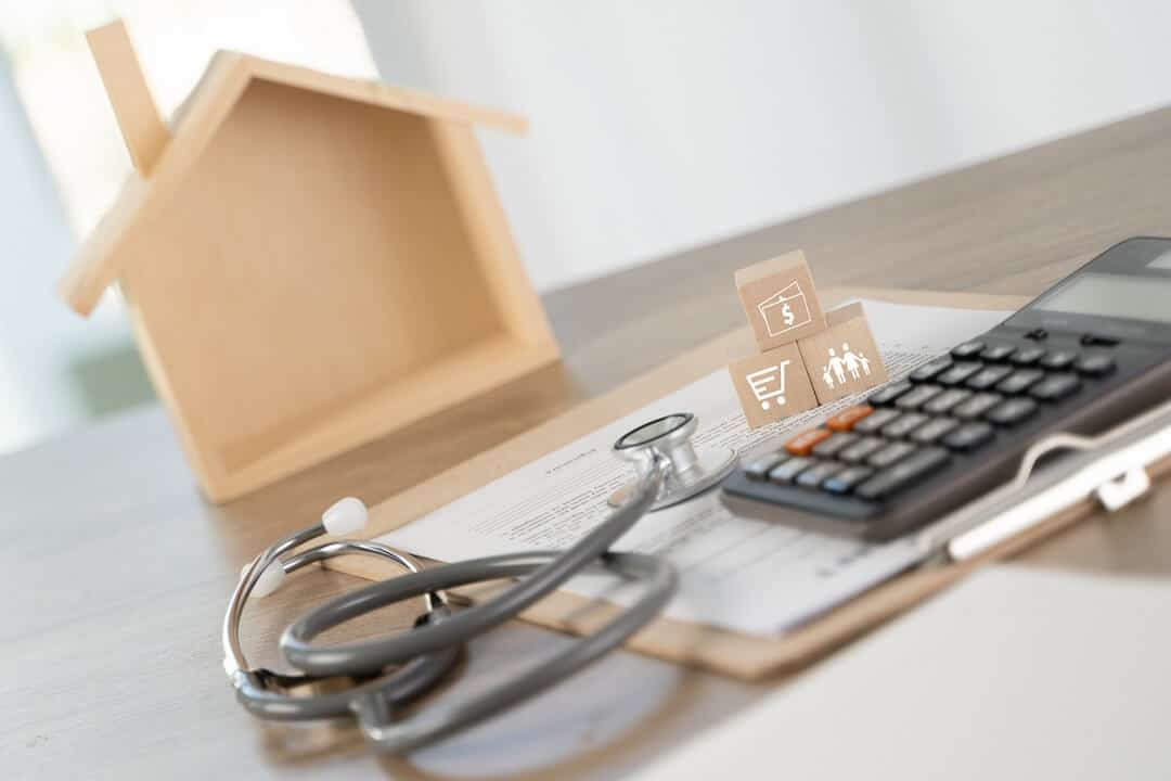 Stethoscope and calculator on top of a mortgage document